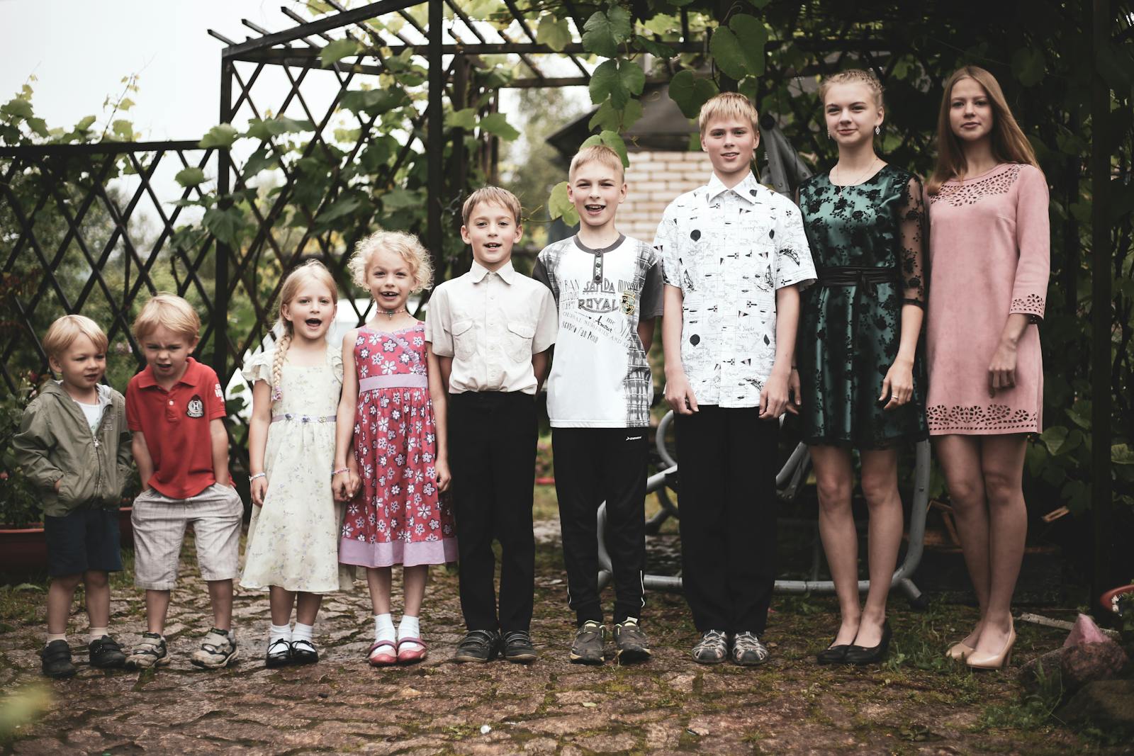 Happy group of children posing in garden setting, showing togetherness and joy.